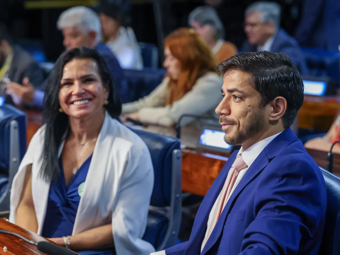 A Dra. Ivone Duque e o Dr. Victor Hugo Passos Ferreira lado a lado, sorrindo, sentados à bancada.